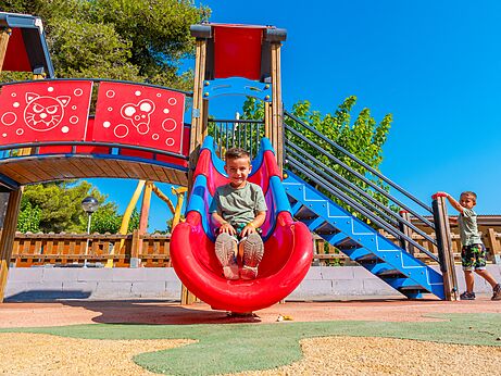 Bunte Rutsche und Spielplatz mit lachenden Kindern auf dem Campingplatz CAPFUN Alba in CREIXELL (43).