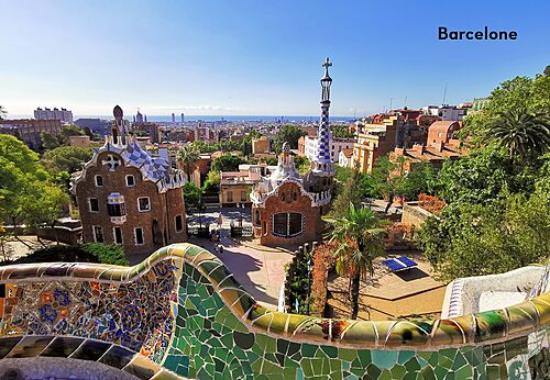 Colorful mosaic bench and Gaudí houses at Park Güell, Barcelona.