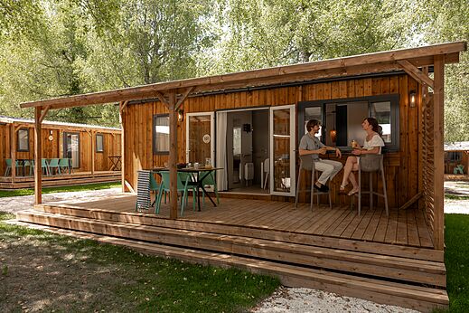 Modernes Mobilheim mit Holzterrasse und Barbereich auf dem Campingplatz CLICOCHIC Aloua.