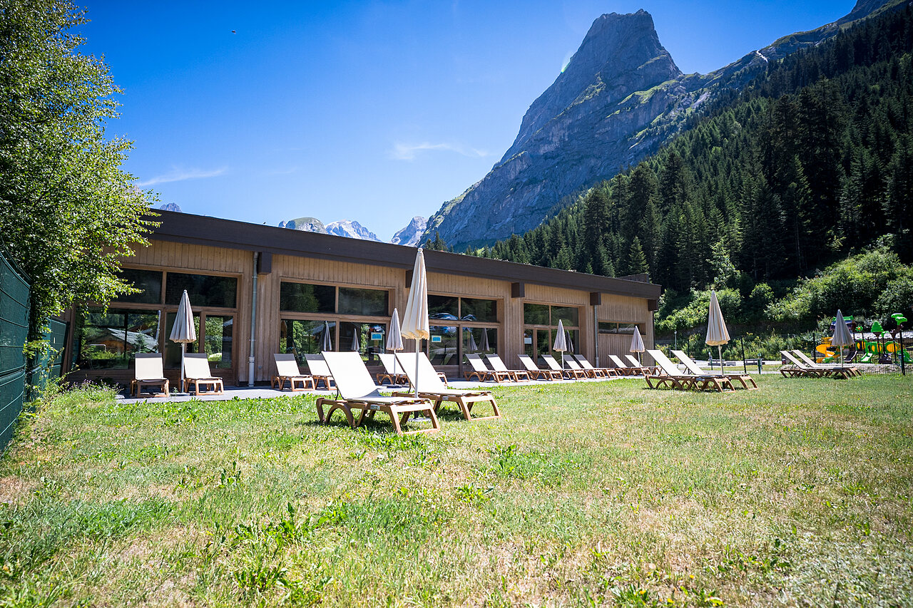 Sun loungers, playground, mountain at CLICOCHIC Alpes Lodges campsite in Pralognan la Vanoise (73).