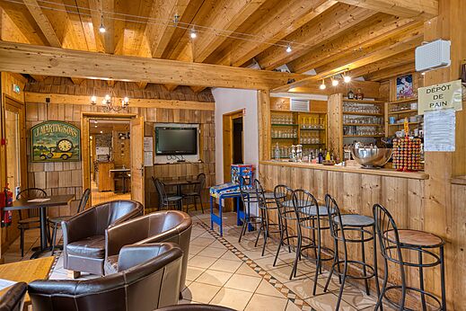 Bar und Lebensmittelgesch�ft mit h�lzernem Entspannungsbereich auf dem Campingplatz CLICOCHIC Alpes Lodges in Pralognan la Vanoise (73).