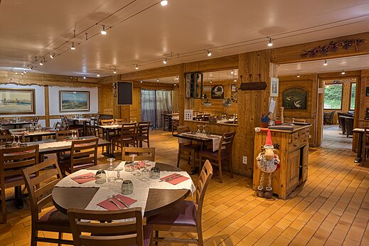 Gem�tliches Restaurant mit gedeckten Tischen und Holzdekor auf dem Campingplatz CLICOCHIC Alpes Lodges in Pralognan la Vanoise (73).