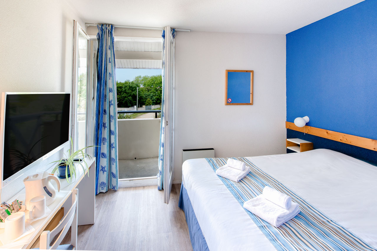 Zimmer mit Doppelbett, Balkon auf Campingplatz CAPFUN Oc�ane in Andernos.