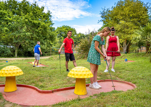 Familie spielt Minigolf auf einem Außenplatz auf dem Campingplatz CAPFUN An Trest in SARZEAU (56).