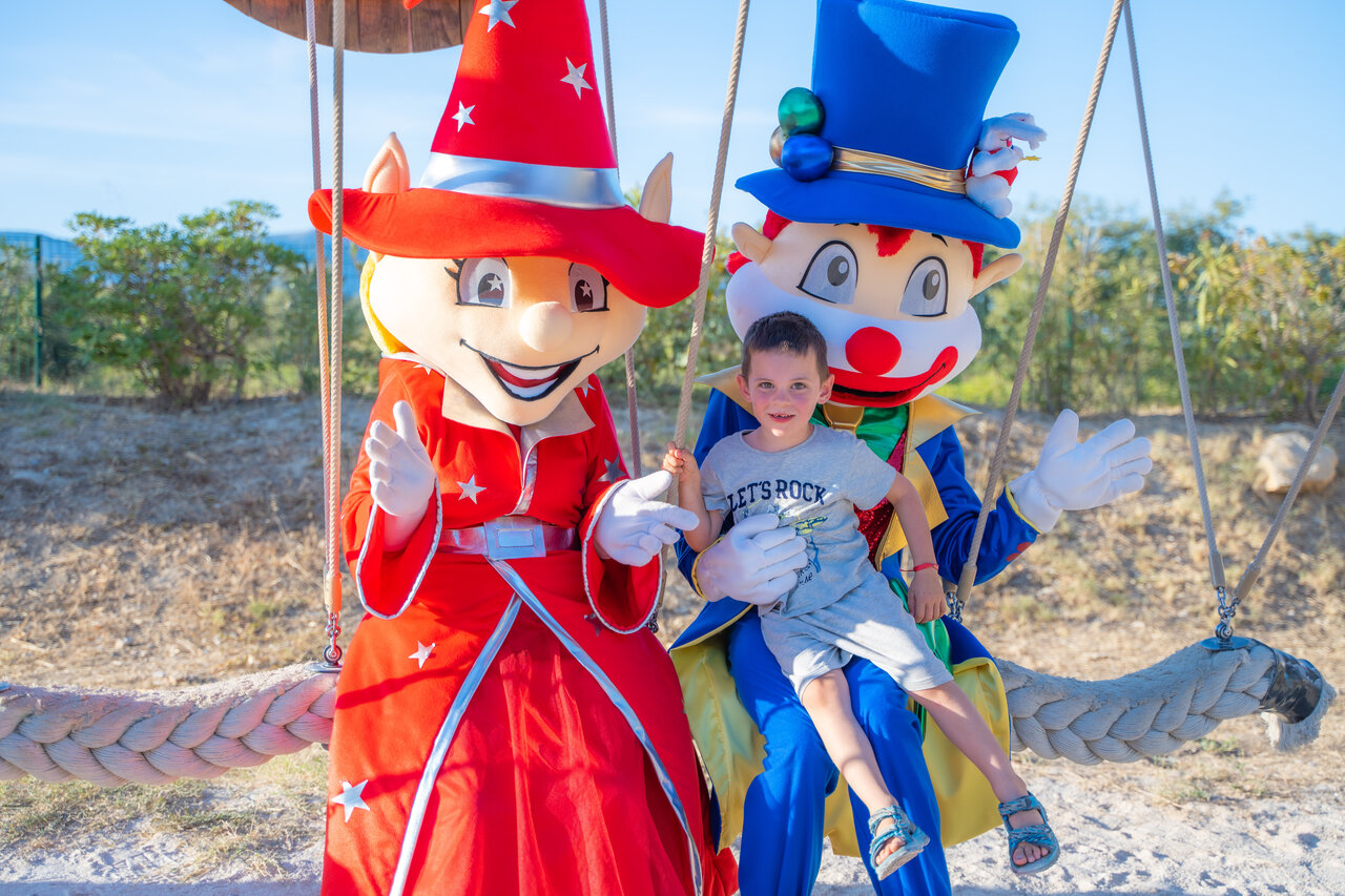 L�chelndes Kind mit Animationsmaskottchen auf dem Campingplatz CAPFUN Arbois du Castellet in LE CASTELLET (83).