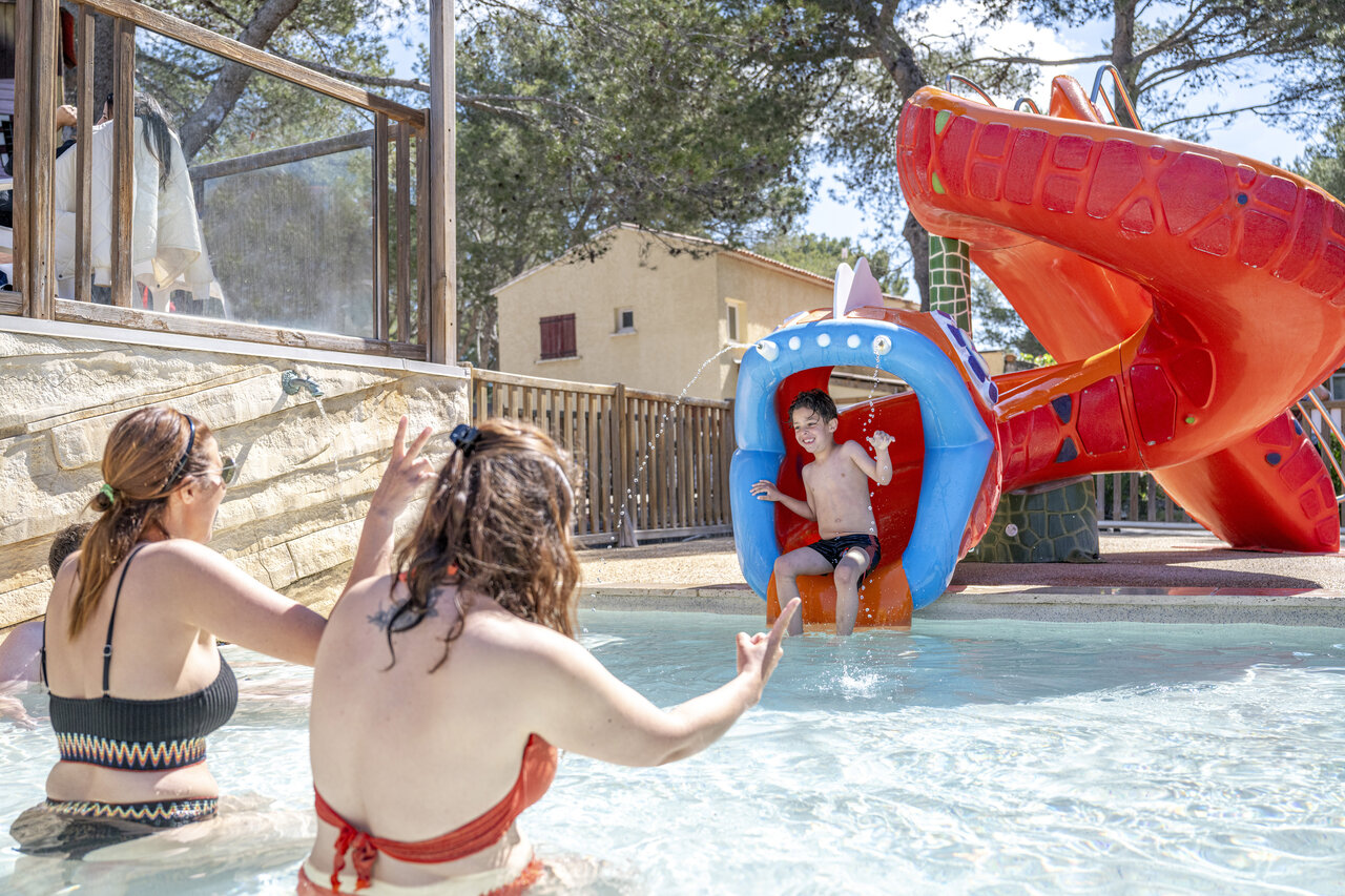 Kind auf Wasserrutsche und Pool, Campingplatz CAPFUN Arbois du Castellet (83).