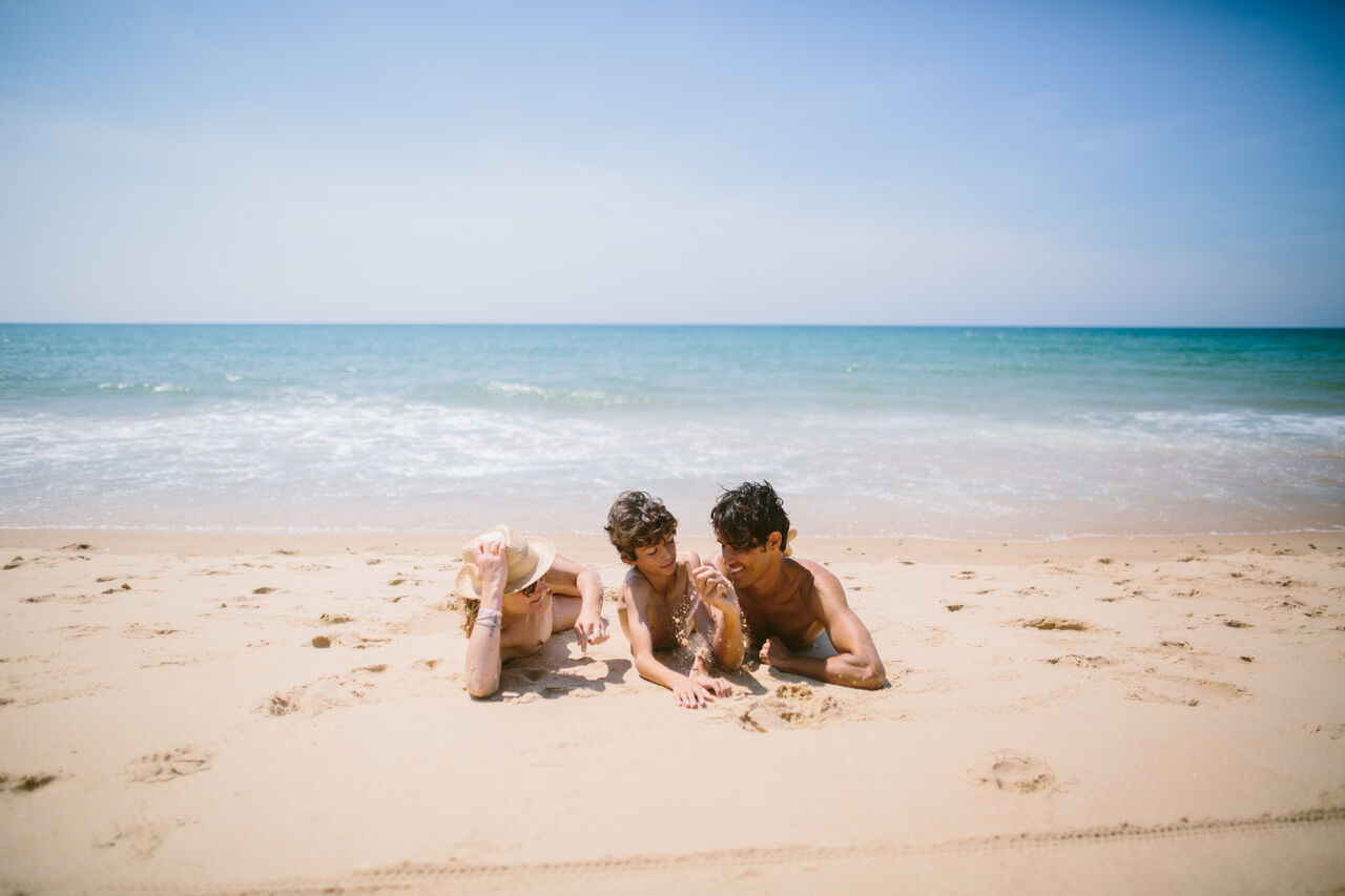 Naturist family enjoying the fine sandy beach at LIBRANOO Naturiste Arnaoutchot campsite in Veille-Saint-Girons, Landes, France.