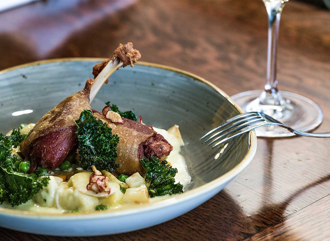 Entenconfit-Gericht mit Gemüse im Restaurant des Campingplatzes LIBRANOO Naturiste Arnaoutchot in Veille-Saint-Girons, Landes, Frankreich.