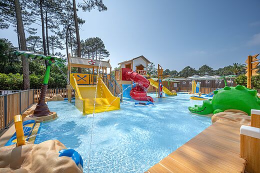 Spielbecken, Rutschen und Wasserspiele auf dem Campingplatz LIBRANOO Naturiste Arnaoutchot in Veille-Saint-Girons, Landes, Frankreich.
