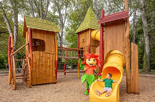 Holzspielplatz, Rutschen, Kind und Maskottchen auf dem Campingplatz CLICOCHIC Art de Vivre in Châteauneuf du Pape (84).