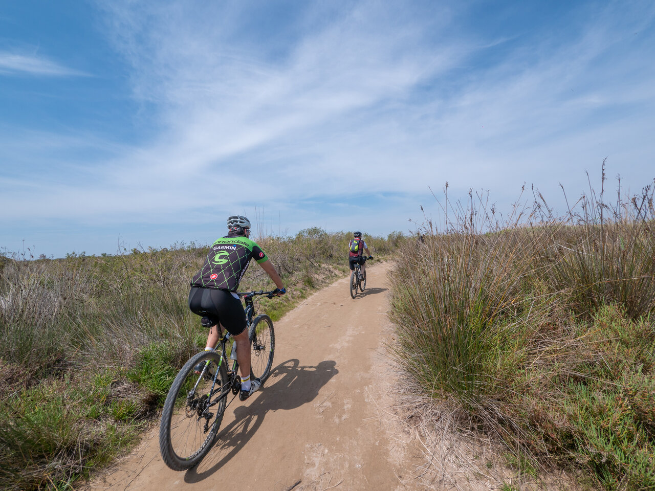 Zwei Mountainbiker auf Naturpfad am Campingplatz CAPFUN Aube in Deltebre, Tarragona.