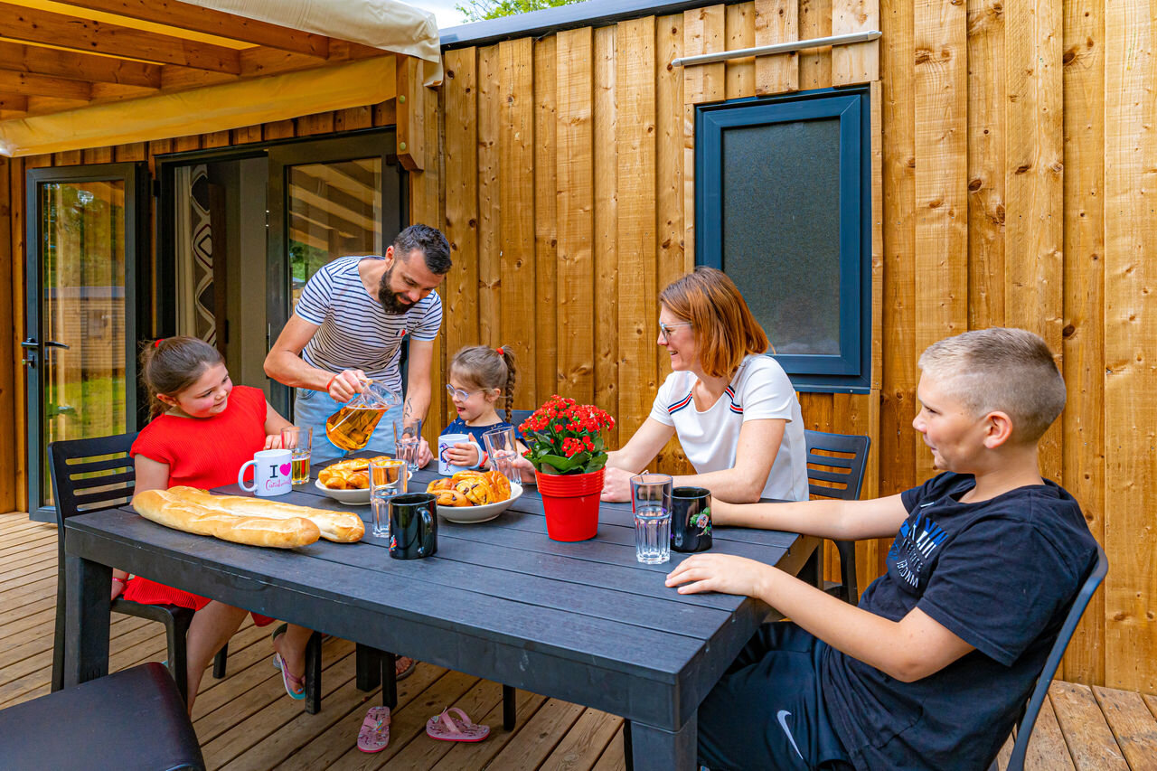 Familie fr�hst�ckt auf der Terrasse eines Mobilheims, auf dem Campingplatz CAPFUN Aube in Deltebre, Tarragona.