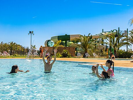 Outdoor swimming pool, children playing, water slides, at CAPFUN Aube campsite in Deltebre, Tarragona.