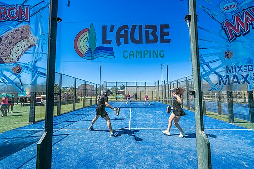 Blauer Padelplatz mit Spielern auf dem Campingplatz CAPFUN Aube in Deltebre, Tarragona.