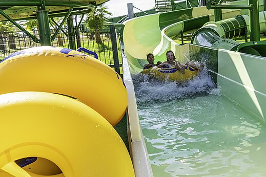 Kinder auf Reifen rutschen Wasserrutsche hinunter auf Camping CAPFUN Aube in Deltebre, Tarragona.