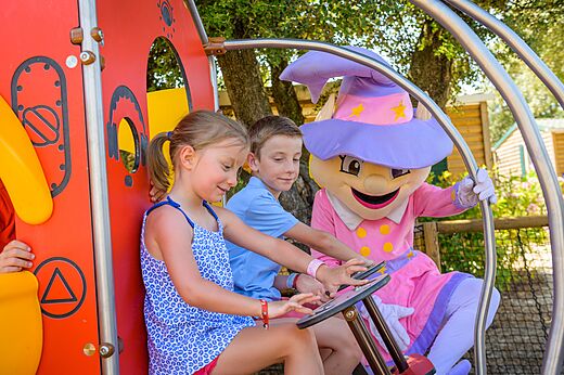 Kinder und Maskottchen auf dem Spielplatz im Camping CAPFUN Aube in Deltebre, Tarragona.