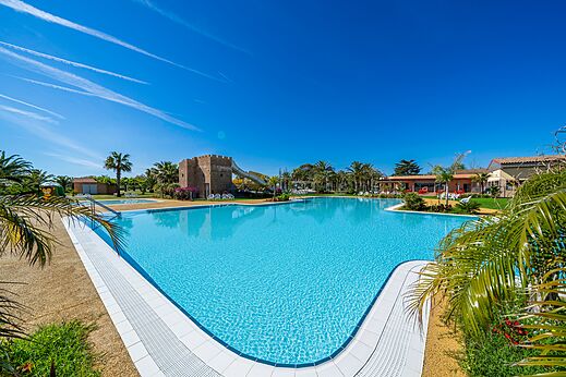 Gro�er Au�enpool mit Rutsche und Palmen auf dem Campingplatz CAPFUN Aube in Deltebre, Tarragona.