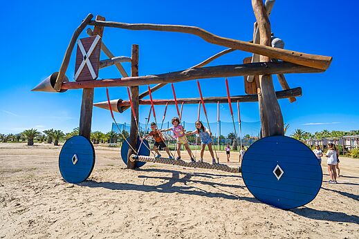 Holzspielplatz mit Kindern auf dem Campingplatz CAPFUN Aube in Deltebre, Tarragona.