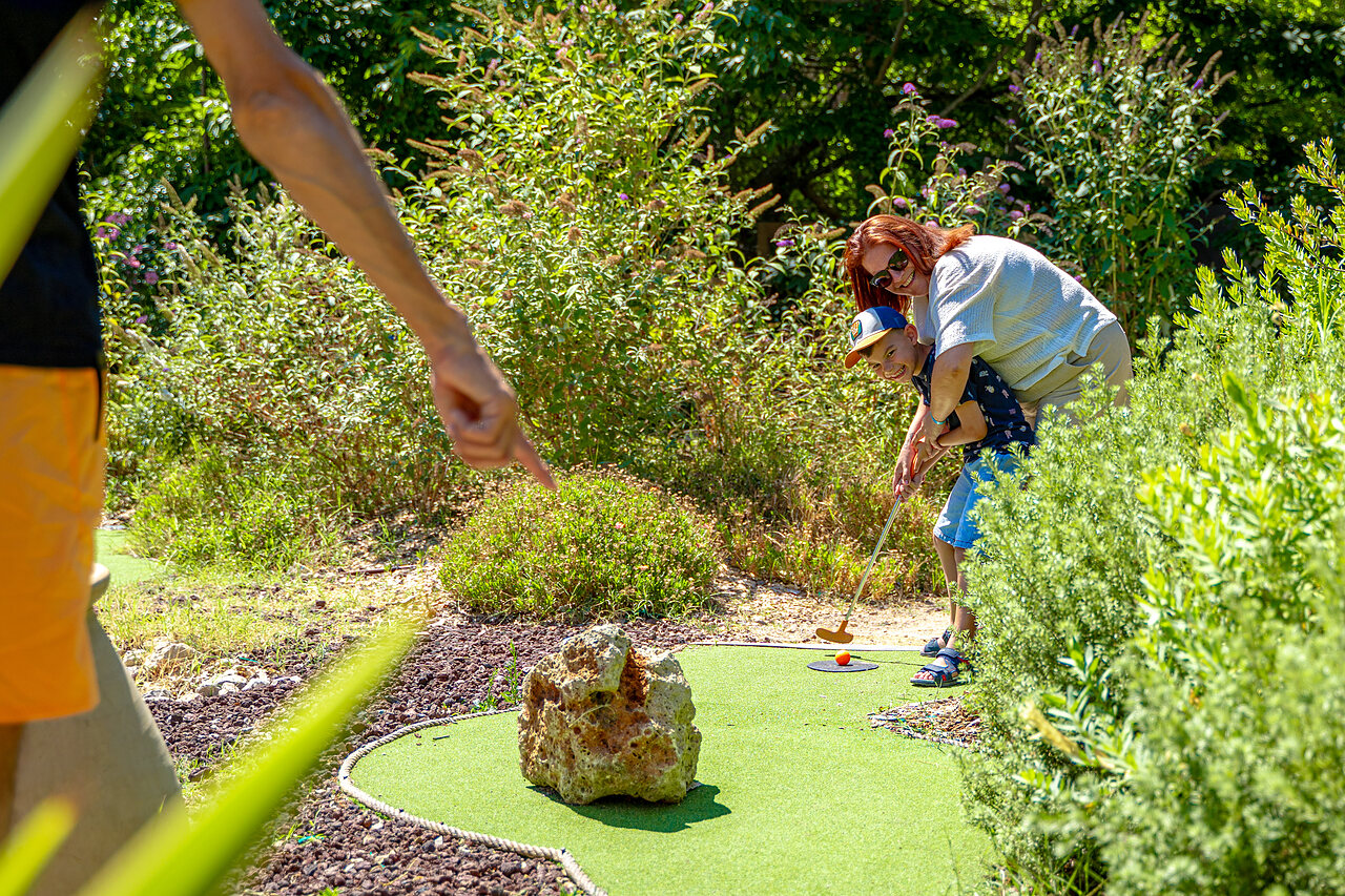 Kind und Erwachsener spielen Minigolf auf einem gr�nen Platz auf dem Campingplatz CAPFUN Aubr�des in Puget sur Argens (83).
