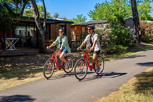 Couple à vélo sur allée du camping CAPFUN Aubrèdes, Puget sur Argens (83).