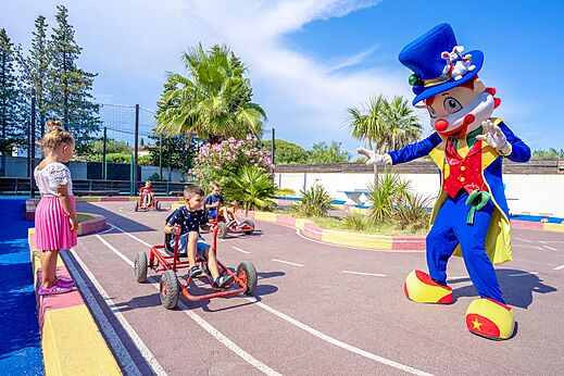 Enfants en karts à pédales et mascotte au camping CAPFUN Aubrèdes, Puget sur Argens (83).
