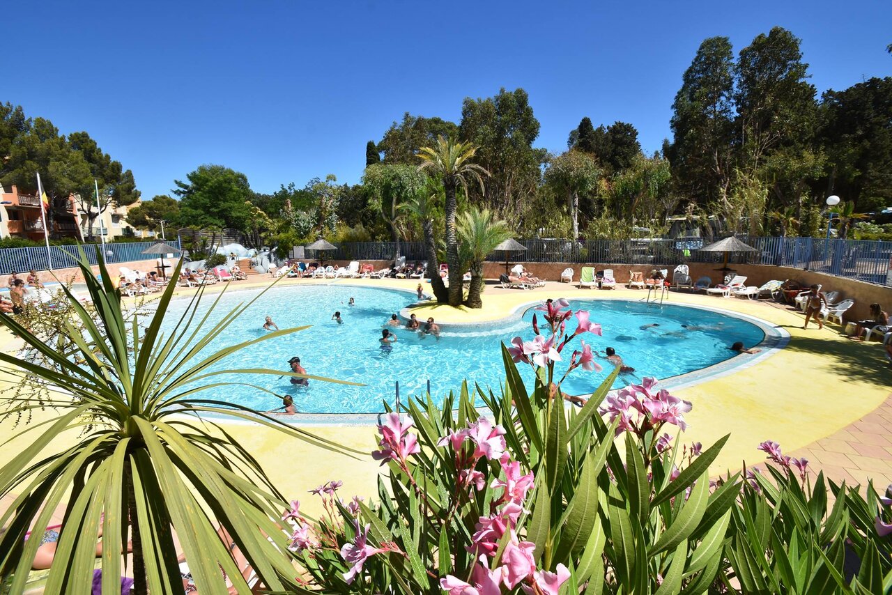 Buiten lagunezwembad, eiland en waterval op camping CLICOCHIC in Cavalaire-sur-Mer.