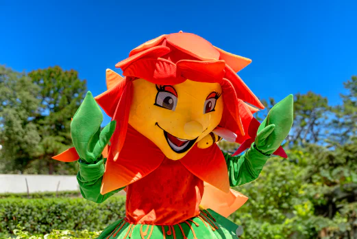 Mascotte fleur souriante avec une abeille pour l'animation au camping CLICOCHIC Baie de Cavalaire.