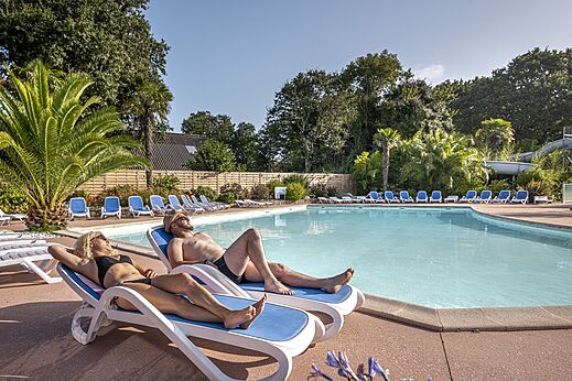 Außenpool, Stühle und Urlauber auf dem Campingplatz CLICOCHIC Baie de Douarnenez.