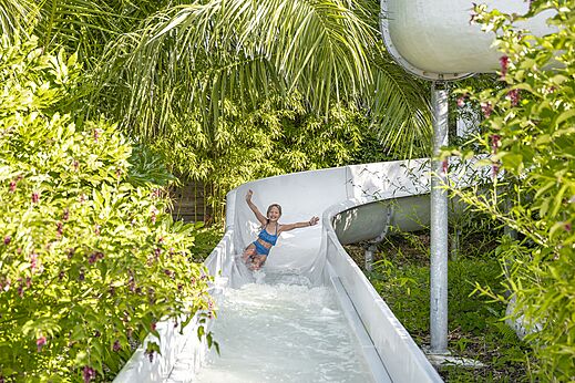 Child sliding down water slide at camping CLICOCHIC Baie de Douarnenez.