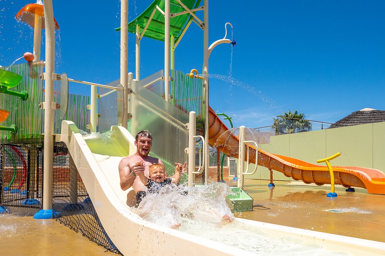 P�re et enfant sur toboggan aquatique, �claboussures au camping CAPFUN Barbacane � NARBONNE (11).