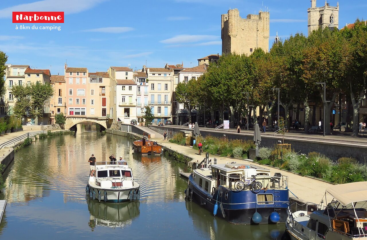 Canal de la Robine avec bateaux, b�timents historiques et tour � Narbonne.