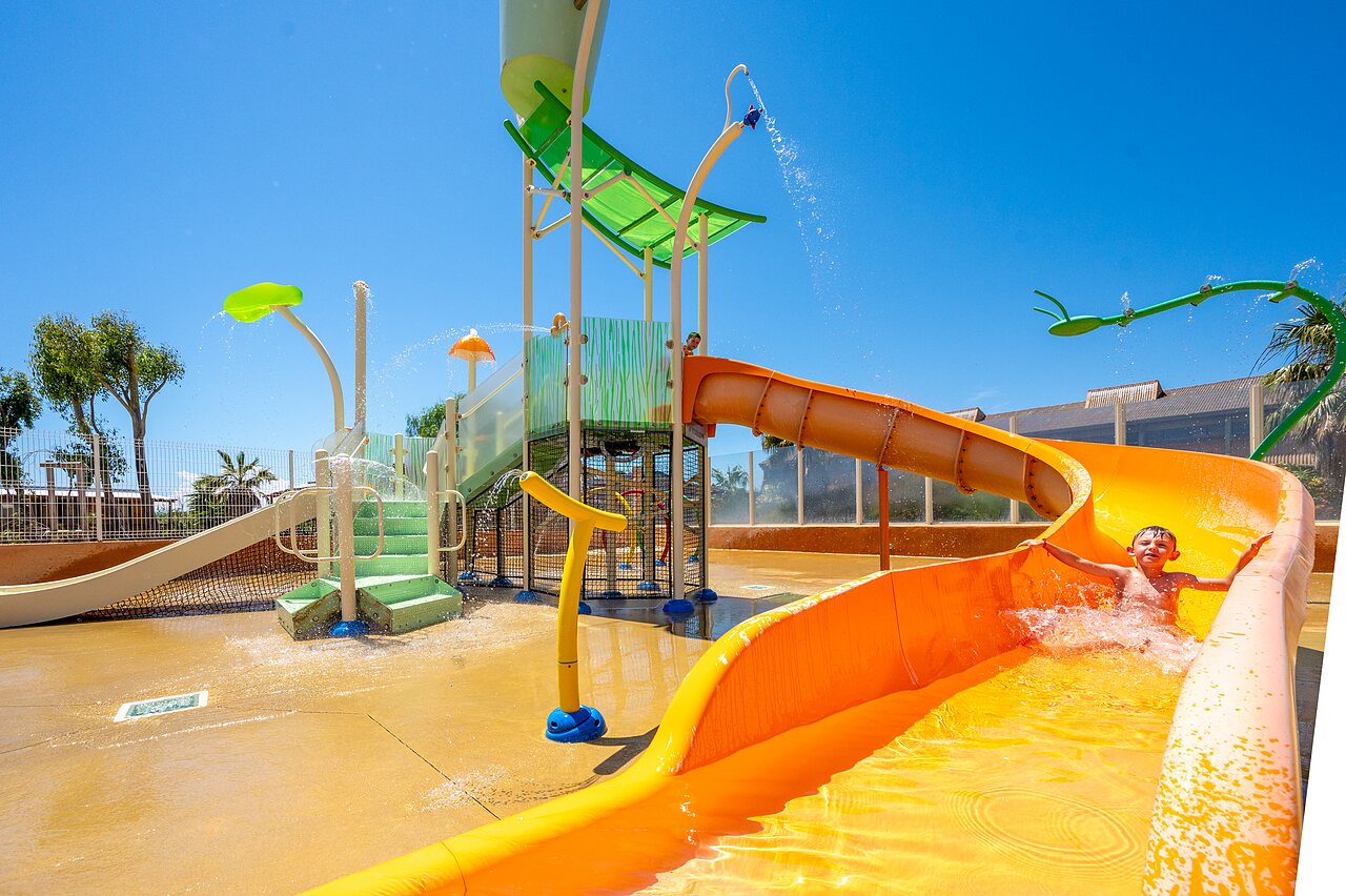 Enfant sur toboggan aquatique orange, jeux d'eau au camping CAPFUN Barbacane � NARBONNE (11).