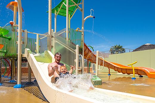 P�re et enfant s'amusant sur le toboggan aquatique au camping CAPFUN Barbacane (11).
