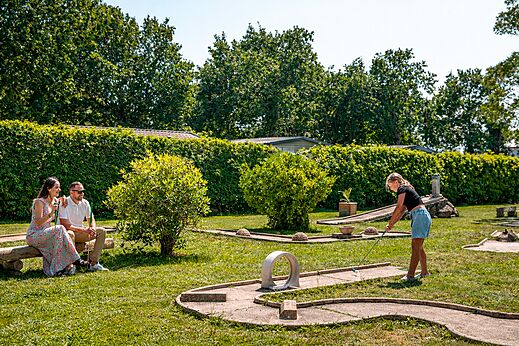 Familie spielt Minigolf auf einem grünen Platz auf dem Campingplatz CLICOCHIC Bastets in Marsanne (26).