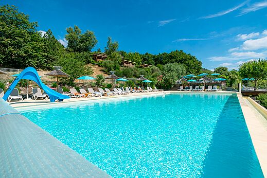 Großes Freibad, blaue Rutsche, Stühle auf dem Campingplatz CLICOCHIC Bastets in Marsanne (26).