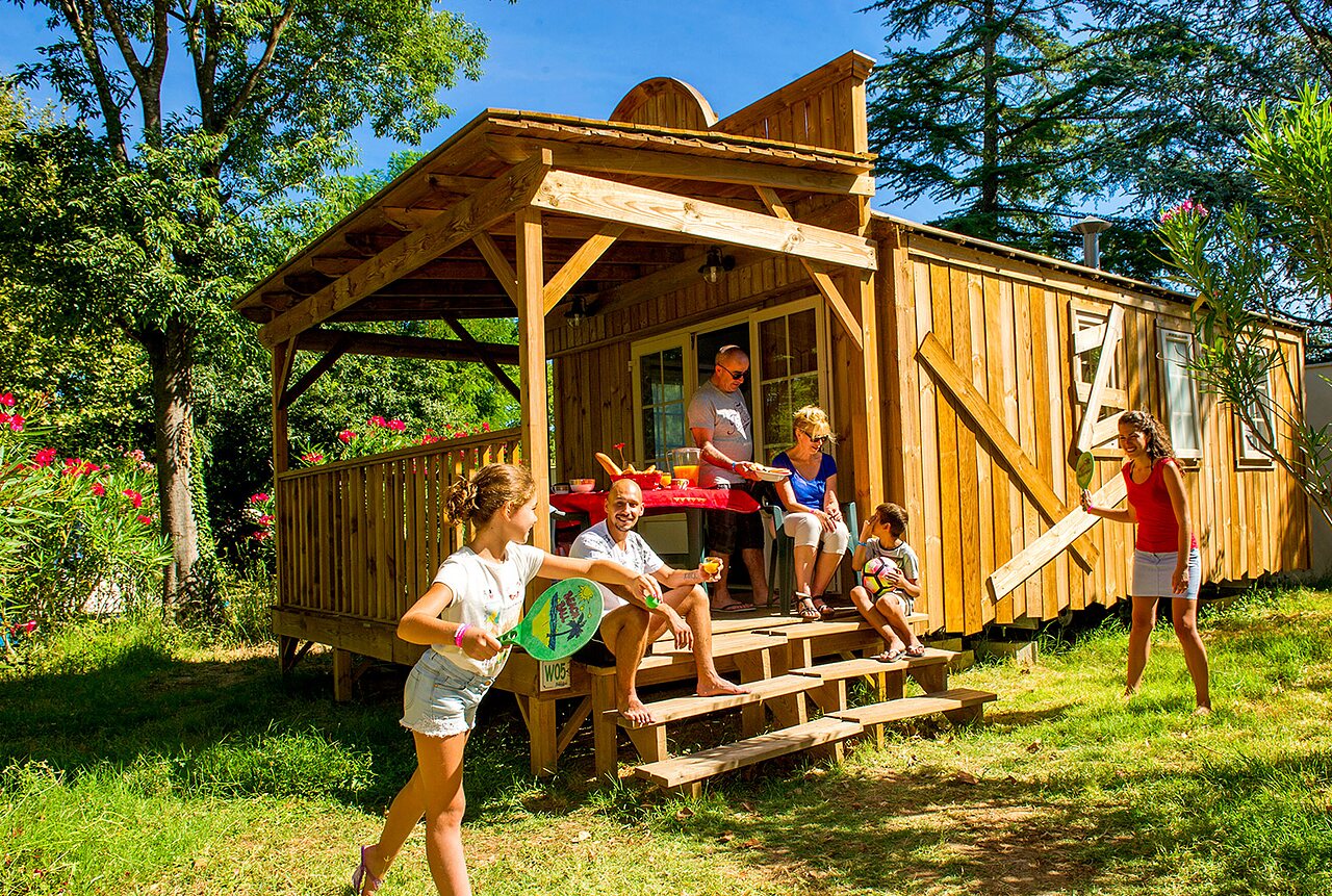 Familie genie�t Holzchalet und spielt auf Campingplatz CAPFUN Bastide in N�mes (30).