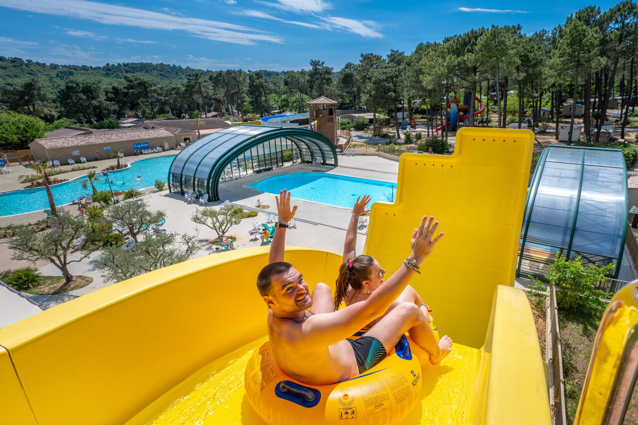 Yellow water slide and outdoor pools at CAPFUN Beauregard MORNAS (84).
