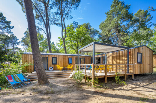 Holz-Mobilheim mit Terrasse und Stühlen auf dem Campingplatz CAPFUN Beauregard in MORNAS (84).