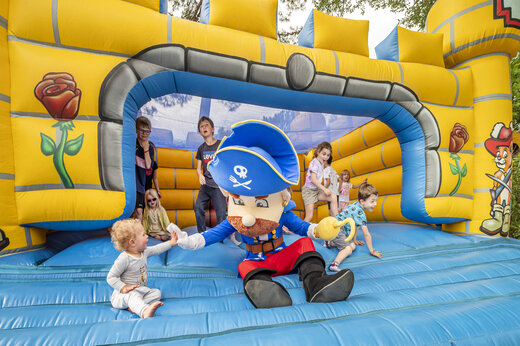 Aufblasbare Piratenburg und spielende Kinder auf dem Campingplatz CAPFUN Beauregard in MORNAS (84).