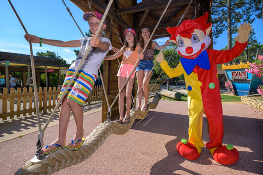 Kinder und Maskottchen auf Seilbrücke im Camping CAPFUN Beauregard in MORNAS (84).