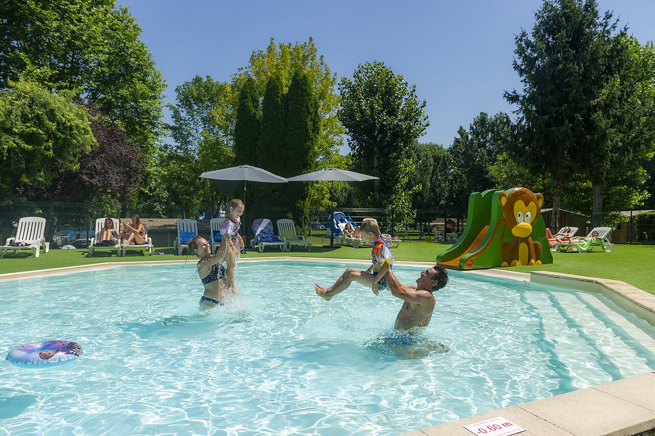 Family enjoying the swimming pool and children's slide at campsite CLICOCHIC Beau Rivage (24).