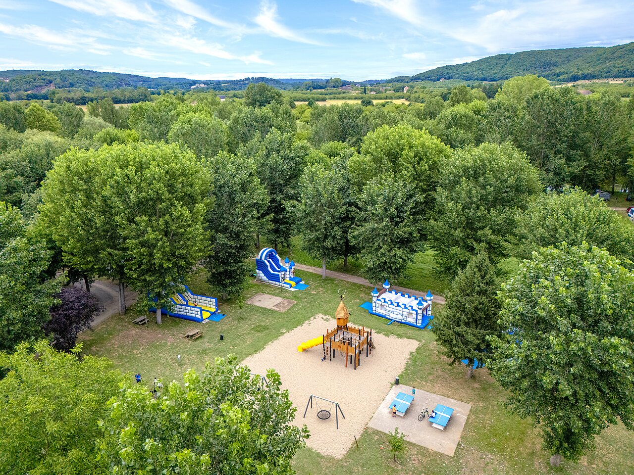 Playground with bouncy castles, slides and swings at CLICOCHIC Beau Rivage campsite in LA ROQUE-GAGEAC (24).