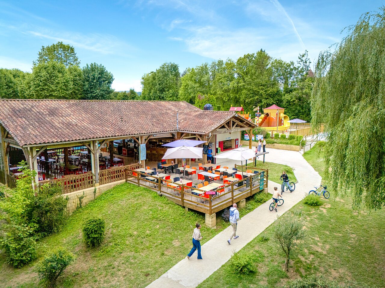 Restaurant-bar with terrace and playground at CLICOCHIC Beau Rivage campsite in LA ROQUE-GAGEAC (24).