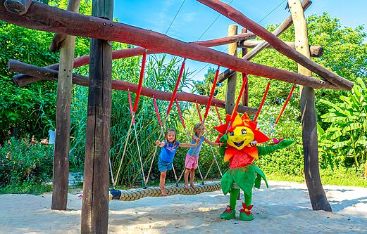 Zwei Kinder und ein Maskottchen auf einer Seilbrücke auf dem Spielplatz des Campingplatzes CLICOCHIC Beau Rivage in LA ROQUE-GAGEAC (24).