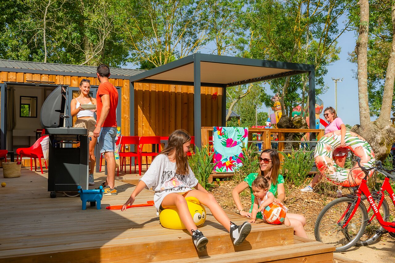 Familie genie�t Terrasse Mobilheim, Grill, Schwimmring, Camping CAPFUN Bel Air (85).