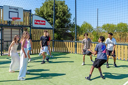 Jugendliche spielen Basketball auf dem Multisportplatz City Stade auf dem Campingplatz CAPFUN Bel Air in Aiguillon sur Mer (85).