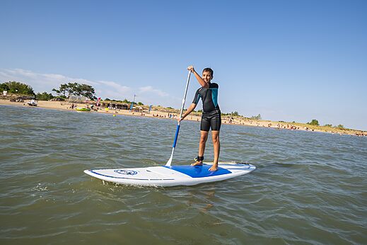 Jugendlicher auf Paddleboard und Strand am Campingplatz CAPFUN Bel Air in Aiguillon sur Mer (85).
