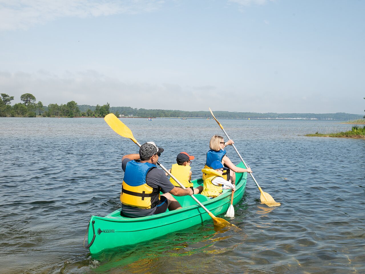 Family canoeing on the lake, water activities at CLICOCHIC Bimbo campsite in BISCARROSSE (40).