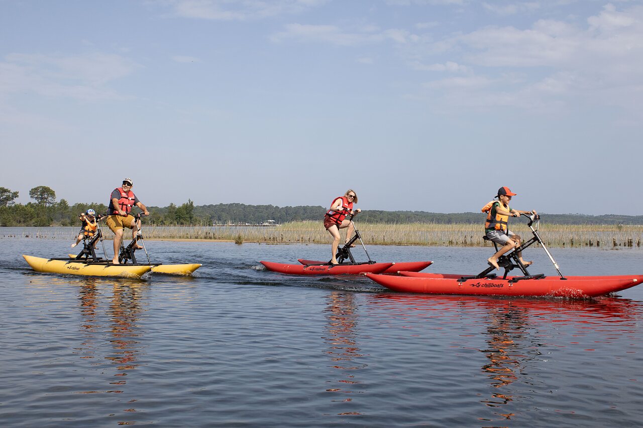 Family on water bikes on lake at CLICOCHIC Bimbo campsite in BISCARROSSE (40).