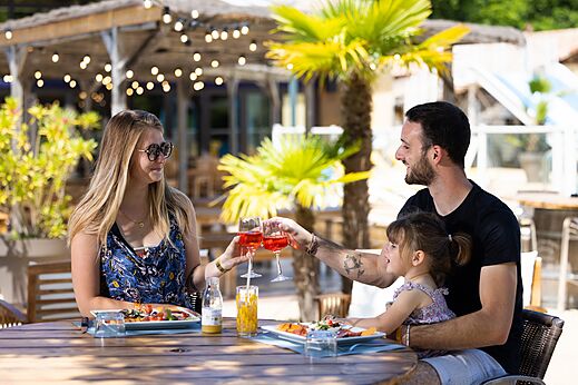 Family dining on the restaurant terrace at CLICOCHIC Bimbo campsite in BISCARROSSE (40).